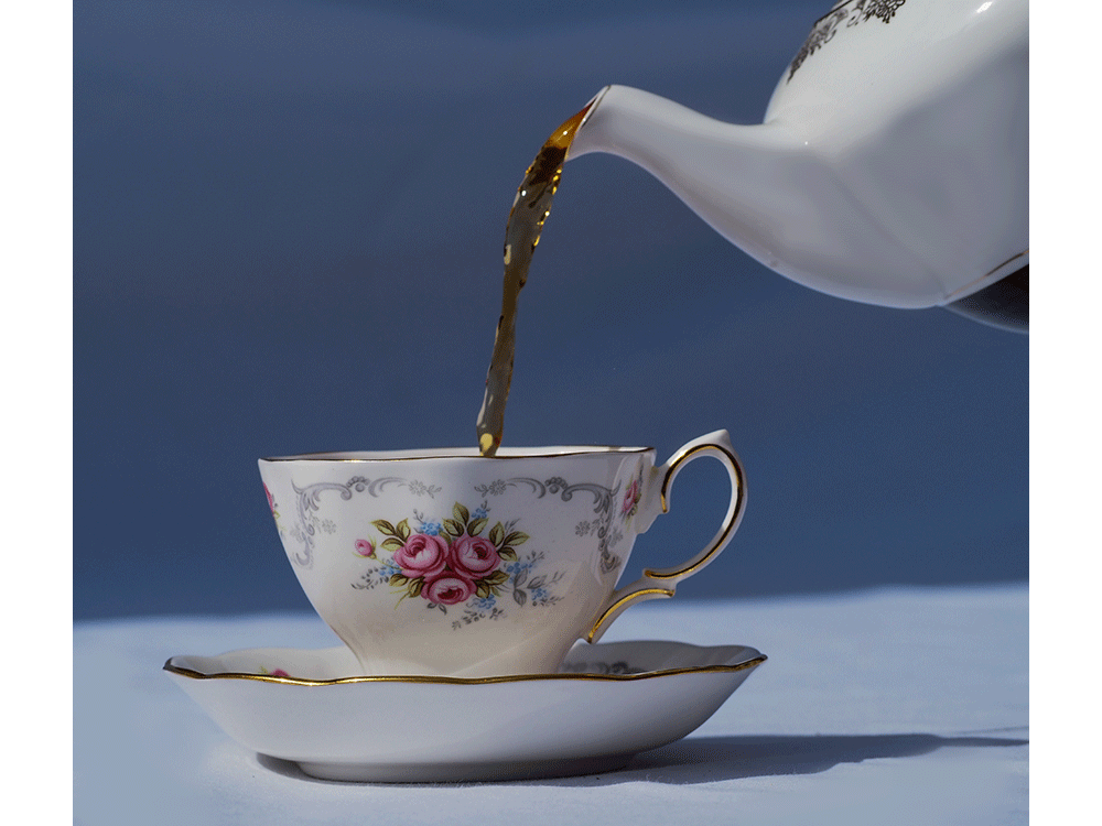 Tea being poured into china cup