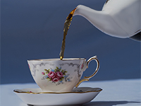 Tea being poured into china cup